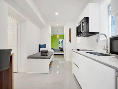a white kitchen with a couch in the middle of it at Casa Verde Design District 5BR Hot Tub in Miami
