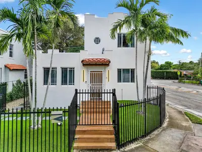a white house with palm trees in front of it at Casa Verde Design District 5BR Hot Tub in Miami