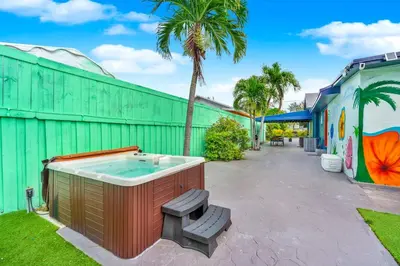a hot tub in a yard next to a building at La Casa Flora Private PoolHot tubSleeps 18 in Miami
