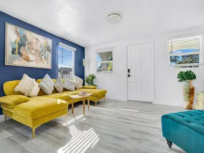 a living room with yellow furniture and blue walls at Villa Bonita 6BR Pool Hot Tub Game Room in Miami
