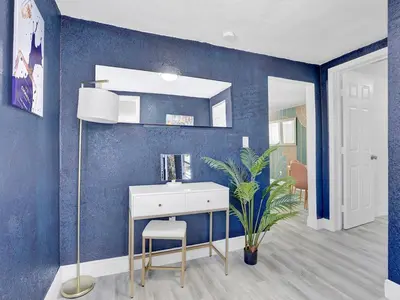 a bathroom with a blue wall with a desk and a plant at Villa Bonita 6BR Pool Hot Tub Game Room in Miami