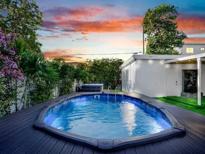 a swimming pool on a deck with a house at Villa Ciao Bella Sleeps 25 Pool Hot Tub in Miami