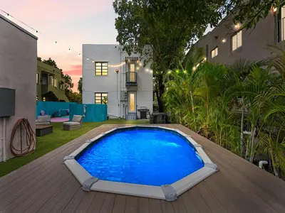 a large blue swimming pool on a wooden deck at Villa mi Amor Walkable Pool & Games in Miami