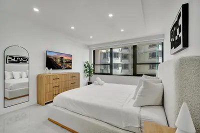 a white bedroom with a large bed and a window at Bright Beachside 4 Bedrooms 2 Bathrooms Condo Pools Gym and Sauna Access 616 in Miami Beach