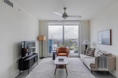 a living room with a couch and a tv at Blueground Riverside pool nr Miami River MIA-155 in Miami