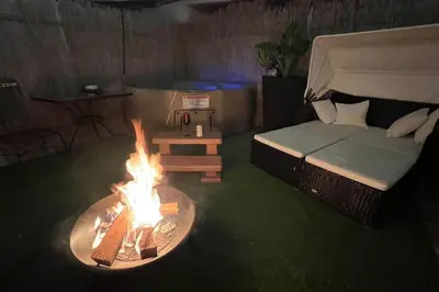 a living room with a fire pit and a bed at Cottage with Hot Tub, Private Firepit, Entrance, Parking BBQ in Miami Gardens