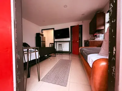 a bedroom with a bed and a table and a kitchen at Cottage with Hot Tub, Private Firepit, Entrance, Parking BBQ in Miami Gardens