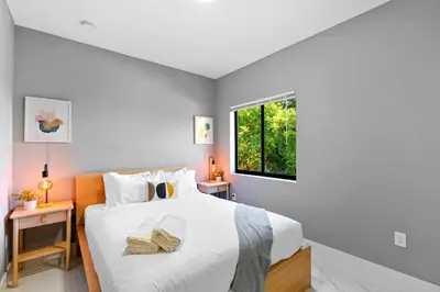 a bedroom with a large white bed with a window at Comfortable Townhouse - Free Parking Included in Miami