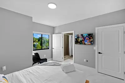 a white bedroom with a bed and a window at Comfortable Townhouse - Free Parking Included in Miami