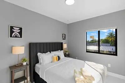 a bedroom with a large white bed with a window at Comfortable Townhouse - Free Parking Included in Miami