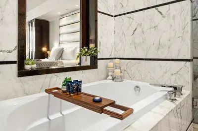 a bathroom with a white tub and a mirror at Stunning Private Studio at Fontainebleau Sorrento - 802 in Miami Beach