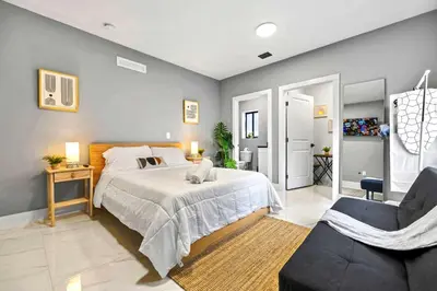 a bedroom with a large bed and a chair at Modern Studio Near Wynwood & Design District in Miami