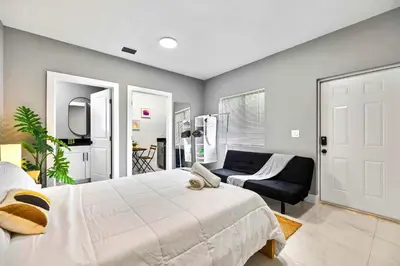 a bedroom with a large bed and a couch at Modern Studio Near Wynwood & Design District in Miami