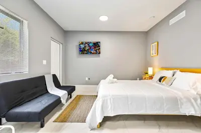 a bedroom with a large bed and a couch at Modern Studio Near Wynwood & Design District in Miami
