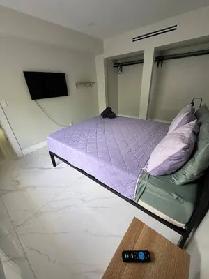 a bedroom with a bed with purple sheets and a remote control at 12 Guest-In The Center of It All in Miami