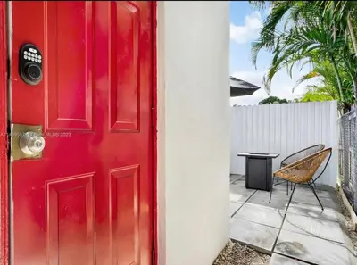a red door with a table and a chair at HOT TUB and Washer & Dryer in Unit in Miami