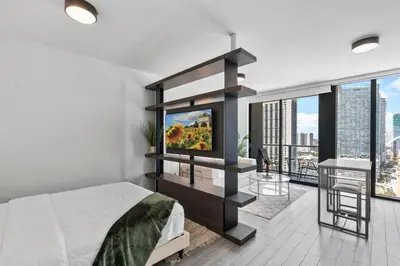 a bedroom with a bed and a tv and a balcony at High-Rise Luxury Condo in Downtown Miami with Ocean Views in Miami