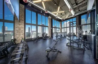 a gym with treadmills and machines in a large room with windows at High-Rise Luxury Condo in Downtown Miami with Ocean Views in Miami
