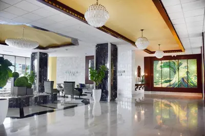 a lobby with chairs and potted plants and chandeliers at Seacoast Suites on Miami Beach in Miami Beach