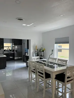 a kitchen and dining room with a table and chairs at North Miami Vacation Home in North Miami Beach