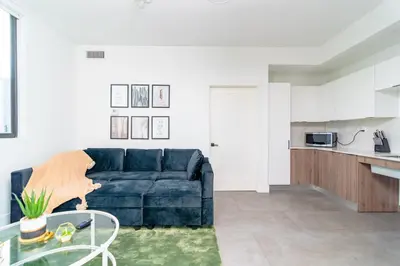 a living room with a blue couch and a kitchen at MetroPark Hotel in Miami