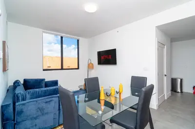 a living room with a blue couch and a glass table at MetroPark Hotel in Miami