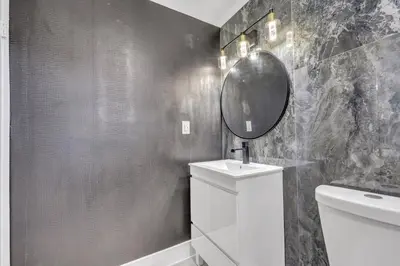 a bathroom with a sink and a mirror on the wall at The Pink Palm Little Havana Pool & Hot Tub in Miami