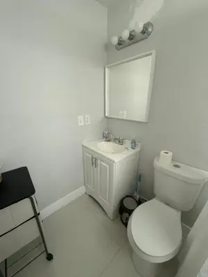 a white bathroom with a toilet and a sink at Suite in Dania Beach in Dania Beach