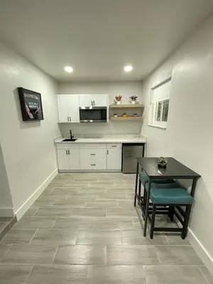 a kitchen with white cabinets and a table and a dining room at The Vice City Suite - Private stay with Free Parking in the Heart of Miami in Miami