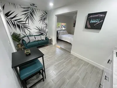 a living room with a couch and a table at The Vice City Suite - Private stay with Free Parking in the Heart of Miami in Miami