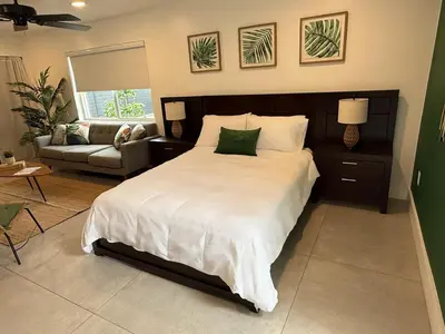 a bedroom with a large bed and a couch at The Miami Tropic Suite - Private Stay with Free Parking in the Heart of Miami in Miami