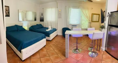 a bedroom with two beds and a table and chairs at south beach apartment 5 min walk to the ocean in Miami Beach