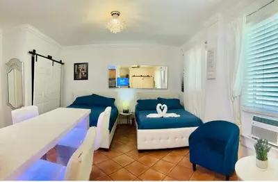 a living room with a table and blue chairs at south beach apartment 5 min walk to the ocean in Miami Beach