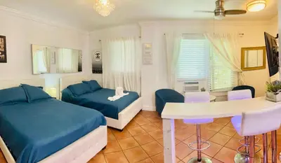 a bedroom with two beds and a table and chairs at south beach apartment 5 min walk to the ocean in Miami Beach