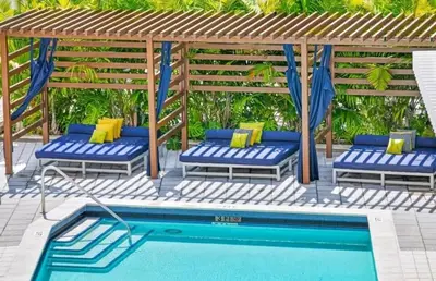 a gazebo with blue chairs and a pool at Midtown Miami Getaway-with pool n parking in Miami