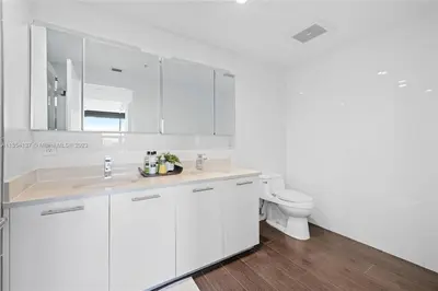 a white bathroom with a sink and a toilet at Midtown Miami Getaway-with pool n parking in Miami