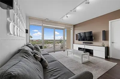 a living room with a large couch and a tv at Midtown Miami Getaway-with pool n parking in Miami