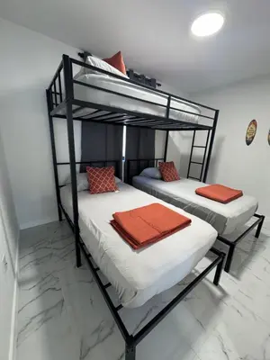two bunk beds with orange pillows on them in a room at Welcome to Miami! in Miami