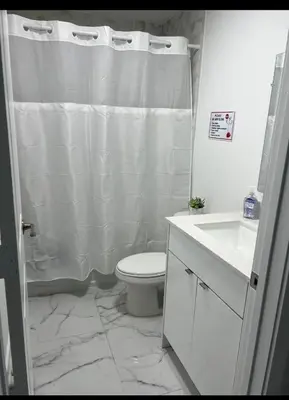 a bathroom with a white shower curtain and a toilet at Welcome to Miami! in Miami