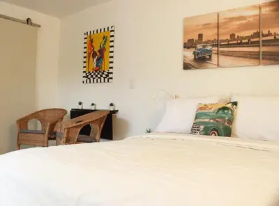 a bedroom with a bed and a desk and a picture at The Havana Nights Guesthouse - Private Stay with Free Parking in the Heart of Miami in Miami