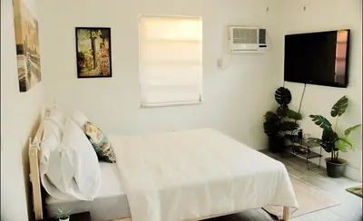 a white bedroom with a bed and a window at The Havana Nights Guesthouse - Private Stay with Free Parking in the Heart of Miami in Miami