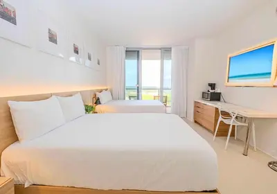 a bedroom with a white bed and a desk and a computer at Luxury Ocean View Apartment 1208 Hallandale Beach in Hallandale Beach