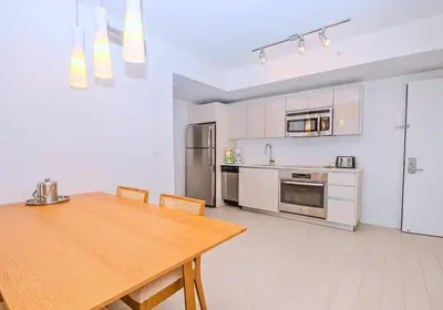 a kitchen with a wooden table and a dining room at Luxury Ocean View Apartment 1208 Hallandale Beach in Hallandale Beach