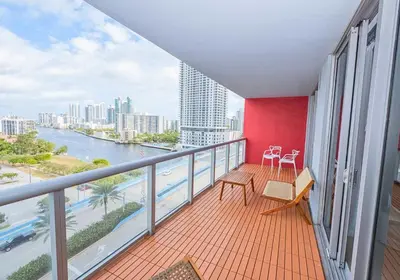 a balcony with a view of a river and buildings at Luxury Ocean View Apartment 1208 Hallandale Beach in Hallandale Beach