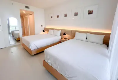 two beds in a hotel room with white sheets at Luxury Ocean View Apartment 1208 Hallandale Beach in Hallandale Beach