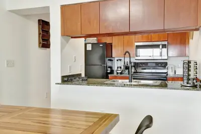 a kitchen with wooden cabinets and a stainless steel refrigerator at Newly Renovated 3BR Condo with Bay Views and Parking in Miami