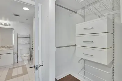 a white bathroom with a toilet and a door at Newly Renovated 1BR APT with Pool, Gym, and WFH in Miami