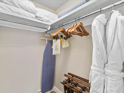 a closet with white shirts and a blue tie at Four Seasons Miami Luxury Two-Bedroom Suite in Brickell - Free Parking in Miami
