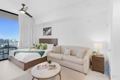 a living room with a bed and a couch at Beautiful Studio with Private Balcony Gym & Pool in Miami