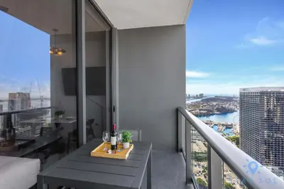 a room with a balcony with a table with wine glasses at Beautiful Studio with Private Balcony Gym & Pool in Miami